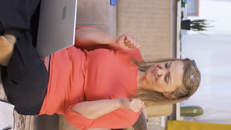 Vertical-video-of-Woman-looking-at-laptop-making-positive-gesture.